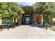 Inviting clubhouse entrance with modern glass doors framed by lush greenery in a well-maintained community at 8516 W Clemente Way, Florence, AZ 85132