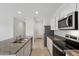 Modern kitchen with stainless appliances, granite countertops, island sink, and bright lighting at 8516 W Clemente Way, Florence, AZ 85132