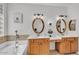 Bright bathroom with double sinks, granite countertops, and separate tub at 8820 W Glenn Dr, Glendale, AZ 85305