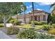 Landscaped front yard featuring mature trees and a well-maintained lawn and a circular driveway at 8820 W Glenn Dr, Glendale, AZ 85305
