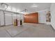 Spacious garage with epoxy floors, storage cabinets, and a roll-up door at 8820 W Glenn Dr, Glendale, AZ 85305