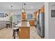 Well-lit kitchen with granite island, stainless appliances, pendant lighting, and tile flooring at 8820 W Glenn Dr, Glendale, AZ 85305
