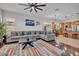 Bright living room featuring a large sectional sofa, modern decor, and an open kitchen layout at 8820 W Glenn Dr, Glendale, AZ 85305