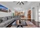 Open living room showcasing a gray sofa, coffee table, adjacent kitchen, recessed lights, and hardwood floors at 8820 W Glenn Dr, Glendale, AZ 85305