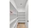 Bright pantry featuring open white shelving, tiled floor, and ample storage space at 8820 W Glenn Dr, Glendale, AZ 85305
