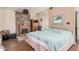 Cozy bedroom features a brick fireplace, a wooden armoire, and a comfortable bed with a patterned blue blanket at 10480 W Martin Rd, Casa Grande, AZ 85194