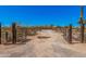 Wide angle shot of the property entrance with desert landscaping and open gate at 10480 W Martin Rd, Casa Grande, AZ 85194