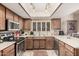 Traditional kitchen with stainless steel appliances, decorative tile floor, and wood cabinets at 10480 W Martin Rd, Casa Grande, AZ 85194