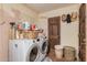 Laundry room with front-load washer and dryer, storage shelves, and a solid wood door at 10480 W Martin Rd, Casa Grande, AZ 85194
