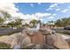 Rock fountain feature amidst lush landscaping and parking area enhancing the community's aesthetic appeal on a bright day at 11260 N 92Nd St # 2102, Scottsdale, AZ 85260