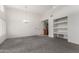 Open living space with carpet, a doorway, built-in shelving, leading into the kitchen area at 11260 N 92Nd St # 2102, Scottsdale, AZ 85260