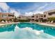 A community pool reflects the blue sky and surrounding condos, complete with ample lounging space at 11260 N 92Nd St # 2102, Scottsdale, AZ 85260
