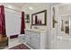 Bright bathroom with white vanity, decorative mirror, and shower with red curtain at 11439 E Bella Vista St, Scottsdale, AZ 85259