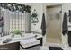 Luxurious bathroom with a soaking tub, walk-in shower, and glass block window at 11439 E Bella Vista St, Scottsdale, AZ 85259