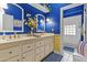 Stylish bathroom with blue walls, double vanity, floral accents, and a separate toilet and shower area at 11439 E Bella Vista St, Scottsdale, AZ 85259