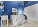Cozy bedroom with blue walls, white bedding, a nightstand, and a closet with sliding doors at 11439 E Bella Vista St, Scottsdale, AZ 85259