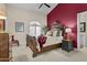 A beautifully decorated bedroom with a wooden bed frame, red accent wall, and neutral-colored walls at 11439 E Bella Vista St, Scottsdale, AZ 85259