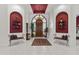 Inviting foyer with red accent walls, hardwood front door, decorative chandelier, and tile floors at 11439 E Bella Vista St, Scottsdale, AZ 85259