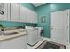 Well-lit laundry room with white cabinets, a utility sink, and a modern washer and dryer set at 11439 E Bella Vista St, Scottsdale, AZ 85259