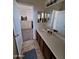 Bathroom featuring a vanity with a large mirror, complemented by stylish tile flooring and an open doorway at 11959 W Pierce St, Avondale, AZ 85323