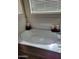 The soaking bathtub has a smooth white finish, a chrome faucet, and three candles around it at 11959 W Pierce St, Avondale, AZ 85323