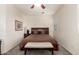 Comfortable bedroom features a ceiling fan, neutral paint, soft carpet, and a padded bench at 11959 W Pierce St, Avondale, AZ 85323