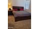 This is a bedroom with carpet, a bed, a nightstand, a lamp, and a window at 11959 W Pierce St, Avondale, AZ 85323