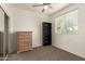 This bedroom is equipped with a ceiling fan, storage, soft carpet, and natural light from the window at 11959 W Pierce St, Avondale, AZ 85323