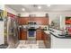 Well-equipped kitchen featuring stainless steel appliances, dark wood cabinets, and granite countertops at 11959 W Pierce St, Avondale, AZ 85323