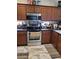 Kitchen with stainless steel appliances, custom wood cabinets, and modern marble floors at 11959 W Pierce St, Avondale, AZ 85323