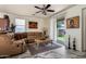 Comfortable living room with neutral tones, ceiling fan, and sliding glass door to backyard at 11959 W Pierce St, Avondale, AZ 85323