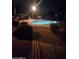 Night view of the community pool, featuring illuminated water and secure fencing at 11959 W Pierce St, Avondale, AZ 85323