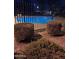 Community pool at night with pristine blue water, secured by a black fence at 11959 W Pierce St, Avondale, AZ 85323