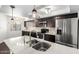 Beautiful kitchen featuring stainless steel appliances, white countertops, dark wood cabinets, and contemporary pendant lighting at 1234 N 84Th Pl, Scottsdale, AZ 85257