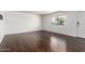 Bright living room featuring dark laminate flooring, a large window, and fresh paint, creating a modern, inviting space at 1234 N 84Th Pl, Scottsdale, AZ 85257