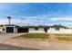 Charming single-story home with a black roof, white brick, black trim and two car garage at 126 E Northern Ave, Phoenix, AZ 85020