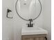 Stylish powder room featuring a modern sink, round mirror, and sleek black faucet at 126 E Northern Ave, Phoenix, AZ 85020