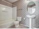 Cozy bathroom featuring tiled flooring, shower-tub combo, and a pedestal sink at 134 W Campbell Ct, Gilbert, AZ 85233