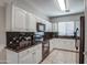 Well-maintained kitchen featuring white cabinets, black appliances, and granite countertops at 134 W Campbell Ct, Gilbert, AZ 85233