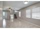 Spacious living room with a ceiling fan, tile flooring, and natural light from multiple windows, leading to staircase at 134 W Campbell Ct, Gilbert, AZ 85233