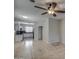 Open-concept living room featuring tile flooring, a ceiling fan, and seamless flow into the adjacent kitchen at 134 W Campbell Ct, Gilbert, AZ 85233