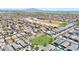 A high aerial view of a large community in a desert setting, complete with commercial areas, a park, and mountain views at 1384 S 222Nd Ln, Buckeye, AZ 85326