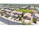 An aerial view of a neighborhood with well-maintained homes, desert landscaping, and a green community space at 1384 S 222Nd Ln, Buckeye, AZ 85326