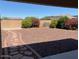 View of the backyard from the covered patio with decorative gravel and flowering bushes at 1384 S 222Nd Ln, Buckeye, AZ 85326