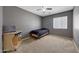 Well-lit bedroom featuring carpet flooring and a desk with a neutral color palette at 1384 S 222Nd Ln, Buckeye, AZ 85326