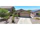 Charming single-story home featuring desert landscaping, a two-car garage, and a welcoming facade at 1384 S 222Nd Ln, Buckeye, AZ 85326