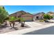 Charming single-story home featuring desert landscaping, a two-car garage, and a welcoming facade at 1384 S 222Nd Ln, Buckeye, AZ 85326