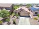 A beautiful aerial view of the front of a one-story home with a desert landscape and a long driveway to a two car garage at 1384 S 222Nd Ln, Buckeye, AZ 85326