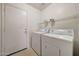 A laundry room featuring a washer and dryer set, complemented by shelving for convenient storage at 1384 S 222Nd Ln, Buckeye, AZ 85326