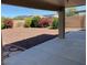 Backyard landscape with patio, decorative rock groundcover and mature bushes in a fenced yard at 1384 S 222Nd Ln, Buckeye, AZ 85326